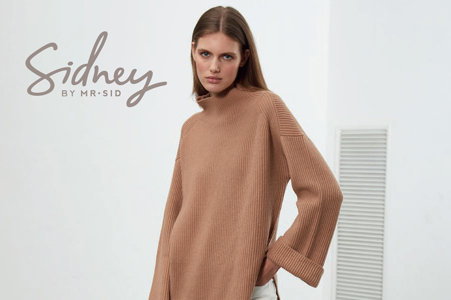 Girl wearing a brown knitted sweater with the words "Sidney by Mr.Sid" By Antonelli - Exclusive Women's Trunk Show